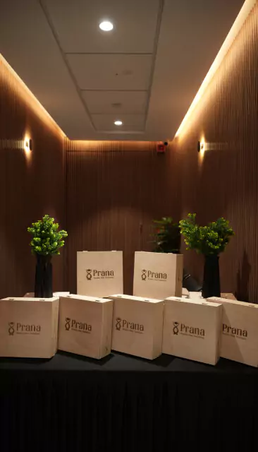 Wooden Prana branded gift boxes displayed on a table with plants