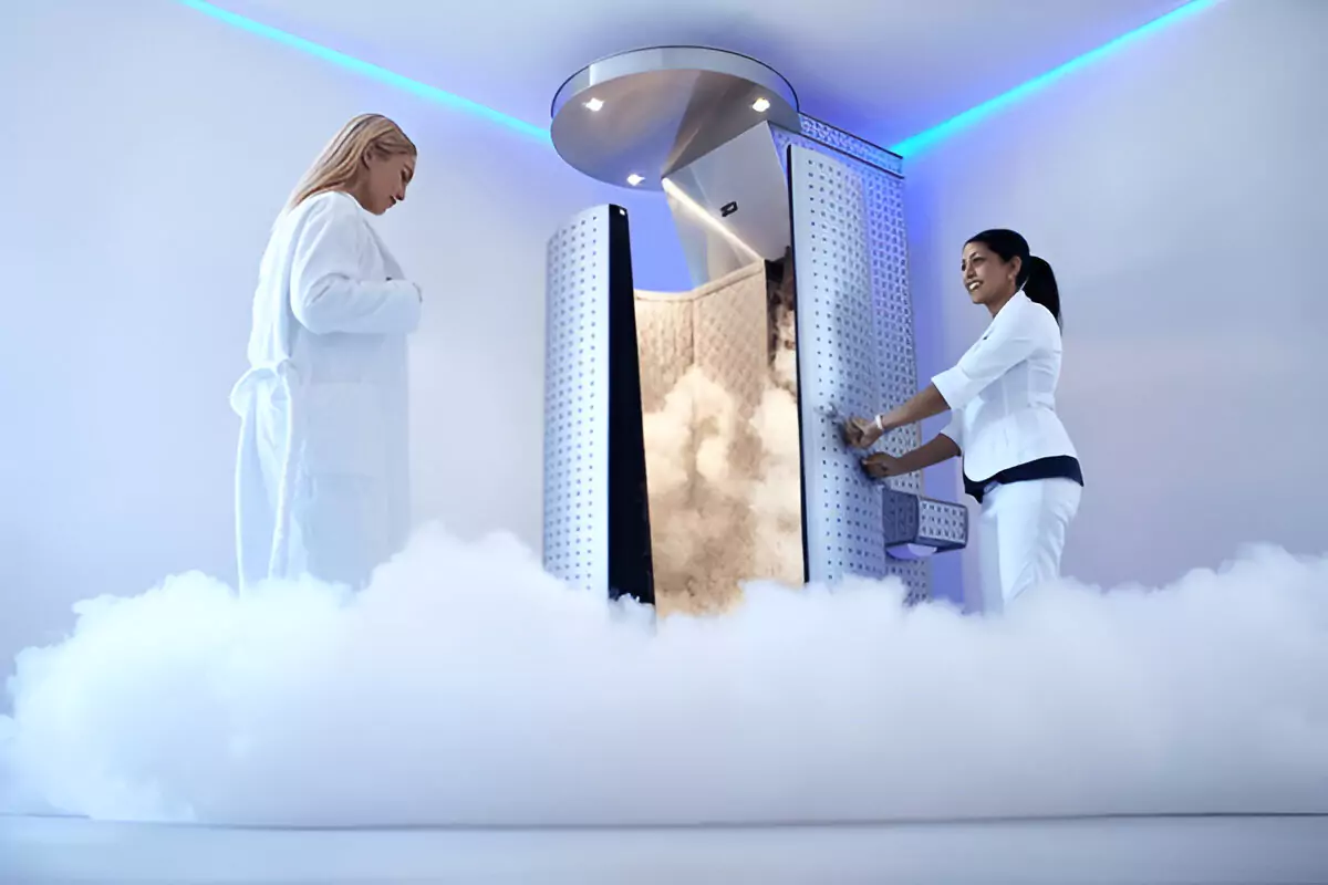 Woman preparing for cryotherapy session with therapist in cooling chamber